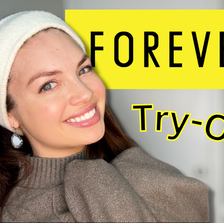Snippet of a YouTube thumbnail of Lesley smiling while wearing a winter headband and dangling earrings. She's wearing a turtle neck sweater. A Forever 21 logo graphic is behind her.